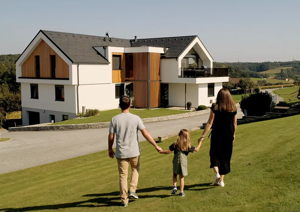 Familie in fata unei case moderne cu acoperis din tigla Bramac 